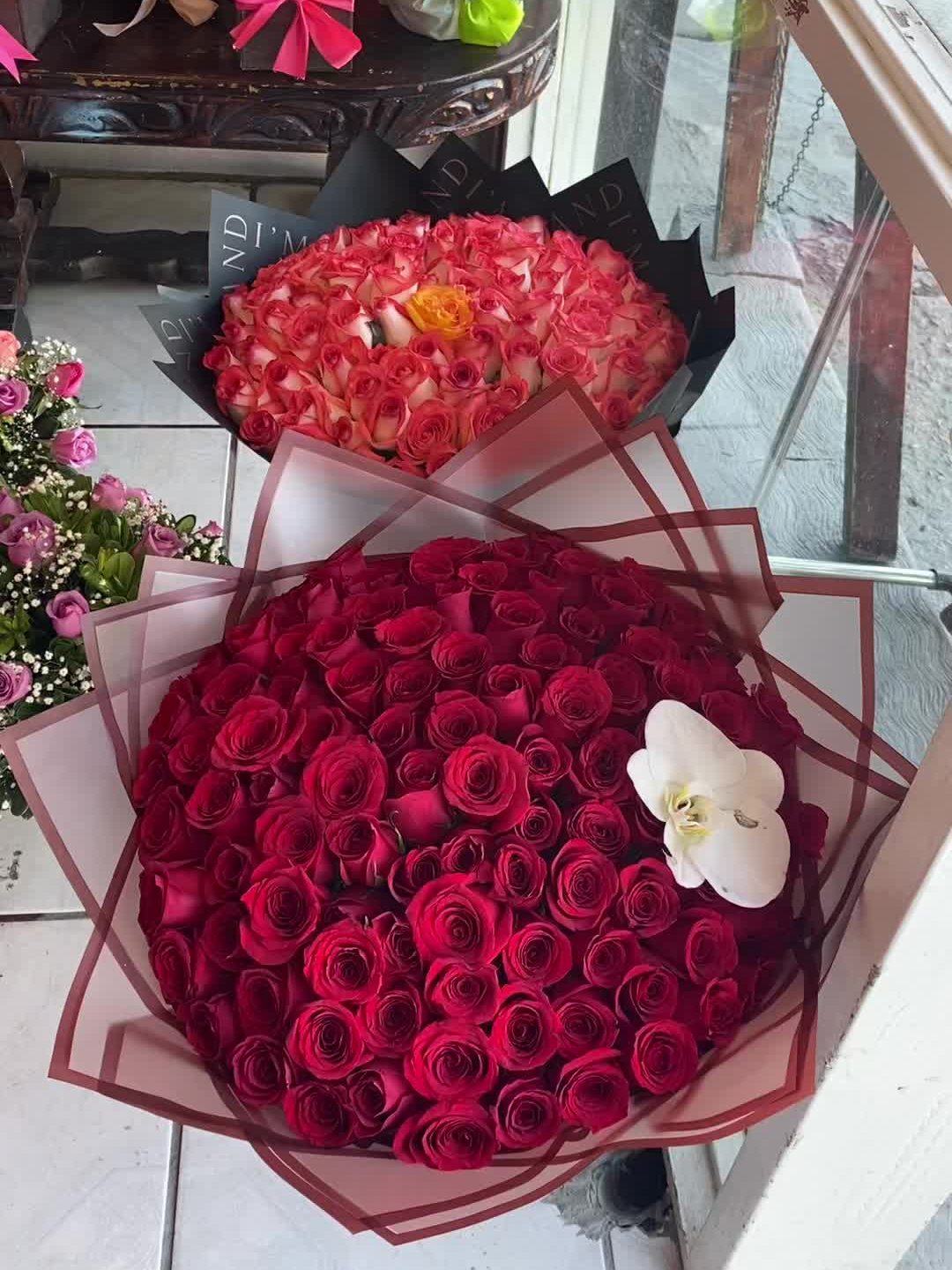 Ramos buchones de rosas rojas y naranjas con una orquídea blanca
